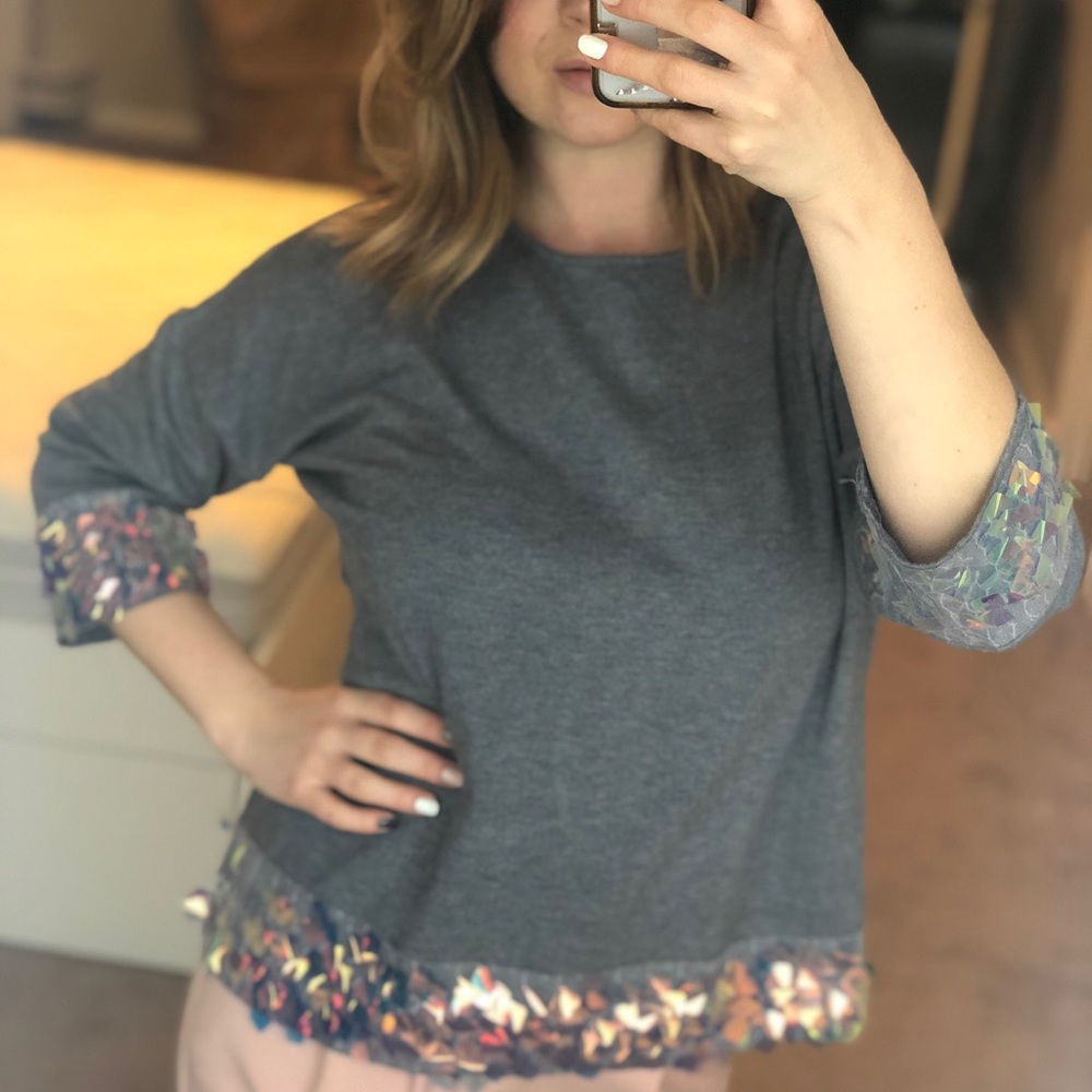 A gray sweater with rainbow sequins.